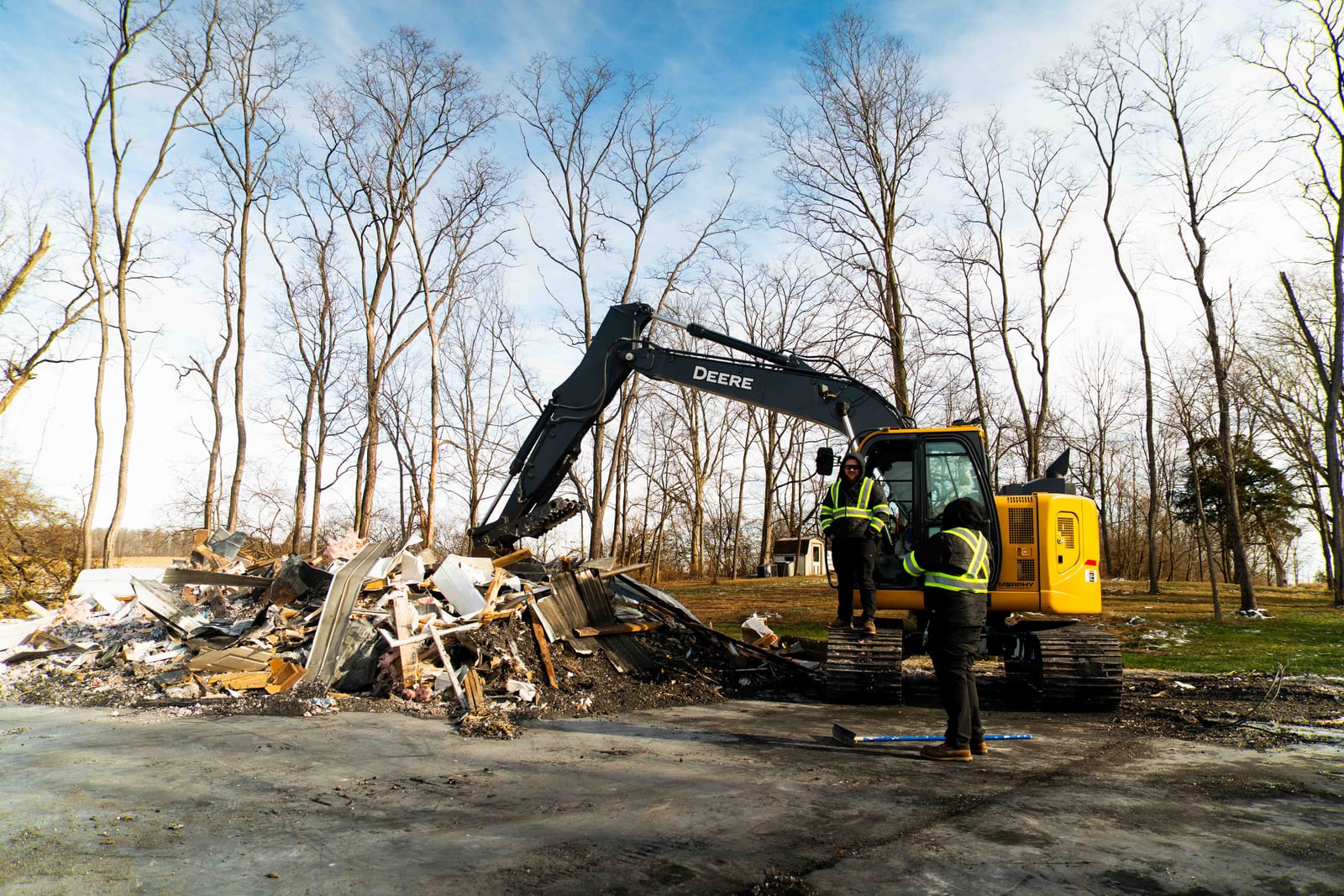 A Limitless excavator and crew member on a fully cleared lot at the end of a job